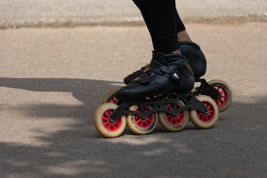 Feet of person with black inline skates