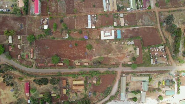 Aerial view of a town and sunlit fields, golden hour in rural Africa - tracking, drone shot. Green bio organic low waste smart agriculture. climate change Paris agreement. Rural Africa village-kenya