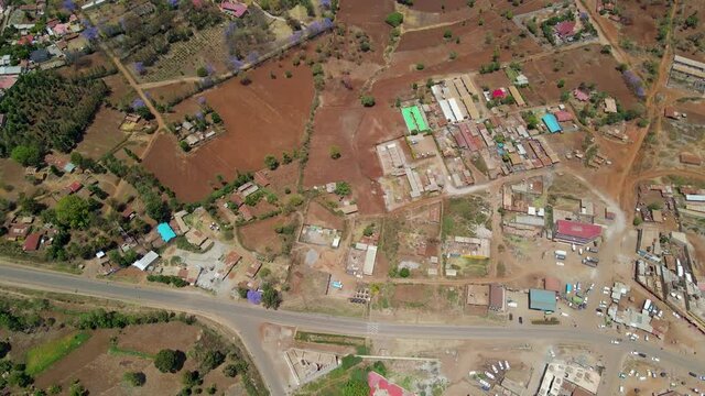 Aerial  of a town and sunlit fields, golden hour in rural Africa - tracking, drone shot. Green bio organic low waste smart agriculture. climate change Paris agreement. Rural Africa village-kenya