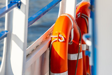 close-up lifebuoy on a boat. Red lifebuoy on ship railing with sea surface