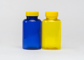 Multi colored transparent plastic pill jars on a white background. Isolated