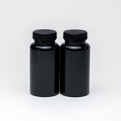 Black plastic pill jars on a white background. Isolated