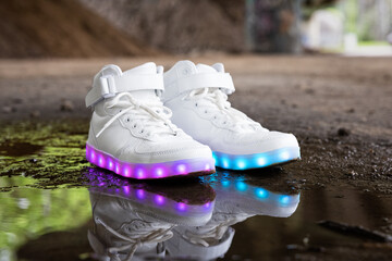 White modern sneakers with colorful LED lights in soles