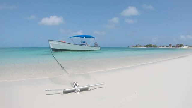 Aluminum Anchor fishing boat on white sand caribbean beach. Turn Right.