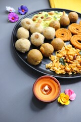 Indian festival food - Diwali Special sweet and salty snacks such as Chakli, Rava laddu, besan ladu, poha chivda, and corn mixture, Namkeen snacks. Diwali Faral from Maharashtra, India. Copy space.