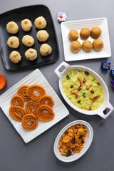 Indian festival food - Diwali Special sweet and salty snacks such as Chakli, Rava laddu, besan ladu, poha chivda, and corn mixture, Namkeen snacks. Diwali Faral from Maharashtra, India. Copy space.