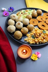 Indian festival food - Diwali Special sweet and salty snacks such as Chakli, Rava laddu, besan ladu, poha chivda, and corn mixture, Namkeen snacks. Diwali Faral from Maharashtra, India. Copy space.
