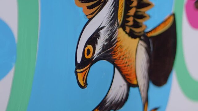 Artist using brush to paint eagle in golden colours