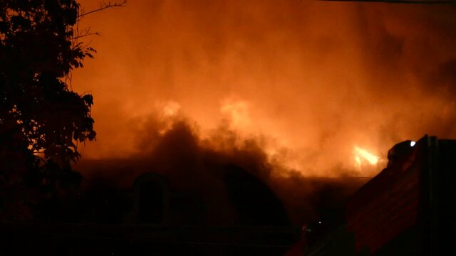 Blazing red hot inferno arson fire services water extinguish flames on smoking burning building