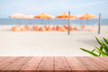 Empty wood table top and blurred sand beach by the sea in tropical resort.Summer banner background...