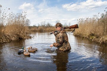 hunter approaches duck decoys on lake