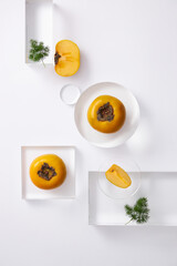 Topview of persimmon and seeds in the petri dish with transparent podium on white background. Research and develop cosmetics in laboratory for advertising
