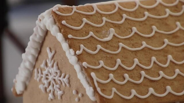 Review of a homemade gingerbread house. Little gingerbread house with royal icing glaze. Christmas gingerbread cookies. Christmas house from ginger cookies. Christmas sweets and gifts.