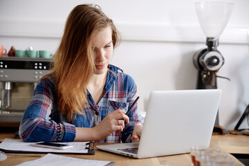 Woman working on laptop at coffee bar