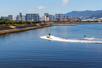 しぶきを上げて水面を走る小型ボートと水上スキー