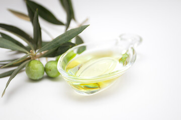 Fresh ripe green olives in an olive oil in glass bowl with leaves