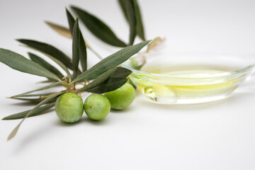 Green olives and olive oil on white background