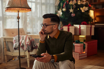 Lonely man using phone at Christmastime