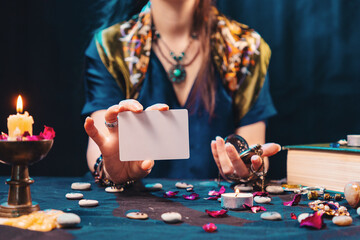 Magic and esotirism concept. The fortune teller shows an empty white tarot card. Mock up....