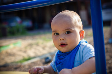 Fototapeta na wymiar Cute happy smiling baby boy walking at children playground outdoors