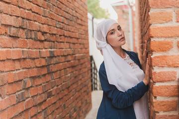 Portrait of female model in fashionable hijab style posing on urban background. Stylish Muslim woman hijab fashion lifestyle portraiture concept and copyspace