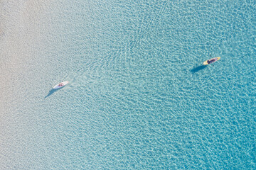 Relaxation in infinite clear blue calm Aegean sea. Aerial drone view of two canoe kayaks