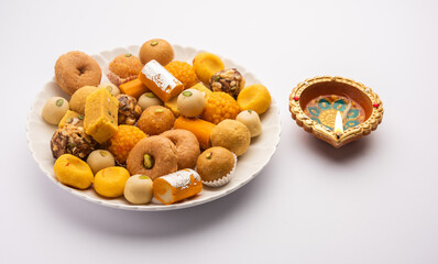 Group of Indian assorted sweets or mithai with diya