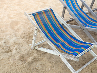 Wooden beach chairs on the sand for a relaxing holiday.