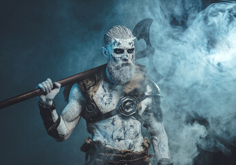 Scary pale skinned warrior with axe in smokey background