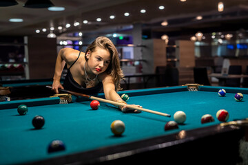 pretty caucasian woman playing snooker at pub