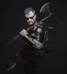 Dangerous fantasy warrior wih two axes in dark background