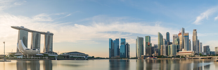 Ultra wide panorama image of Singapore skyscrapers illuminated by morning sunlight early in the morning
