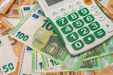 new blank calculator with green buttons lies nicely on new euro banknotes