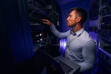 Experienced IT male technician monitoring server performance