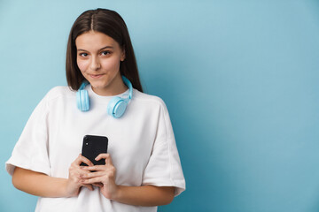Fototapeta premium Young white woman looking at camera using mobile phone