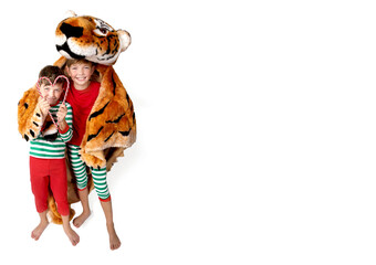 Christmas. boys in Christmas pajamas with Christmas candies in their hands and with a tiger skin the symbol of 2022