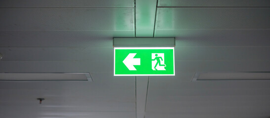 Fire Emergency exit sign on the wall inside building at subway train station. Safety concept