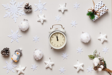 Obraz na płótnie Canvas New Year's winter composition. Alarm clock Christmas gift snowflakes stars balls on a white background. Flat lay top view