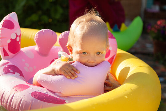 Cute baby play in water outside in swimpool