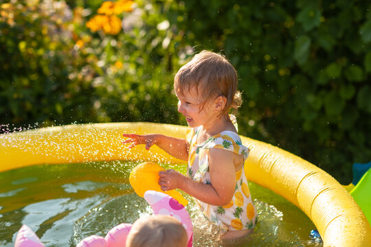 Cute baby play in water outside in swimpool
