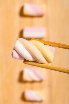 Twisted marshmallow held with chopsticks