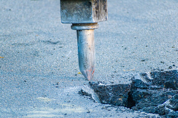 Hydraulic crushing hammer breaking concrete on a construction site