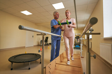 Female patient performing exercises in rehabilitation center at therapy room
