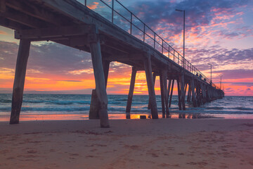 Port Noarlunga jetty with people during pink sunset, South Australia