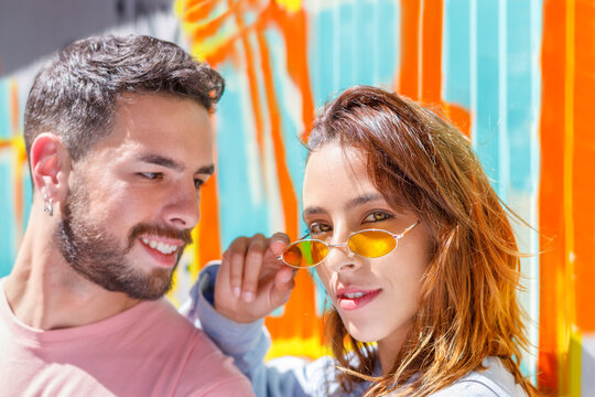 Smiling man looking at woman with sunglasses on sunny day