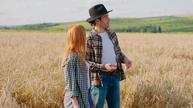 Good looking two farmers analysing the harvest of wheat in the middle of field they have a conversation concept of farming industry. Shot on ARRI Alexa Mini.