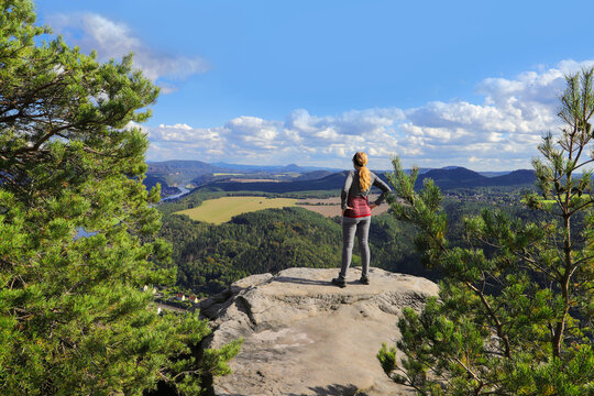 A woman enjoys the view from Lilienstein to the river Elbe, Saxon switzerland - Germany