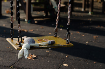 A lost toy on a children's swing in the fall. A toy was lost on the playground. A sad story about a...