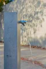 perfil de una fuente publica con el grifo abierto 