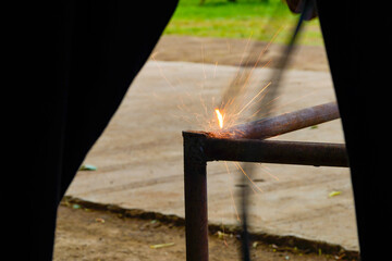 Welders working and jointing iron pipe at the factory